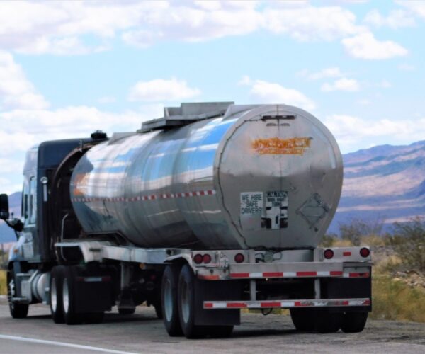 transportation-and-logistics-gas-and-oil-transportation-a-big-rig-tanker-truck-parked-alongside-the_t20_eonL0m